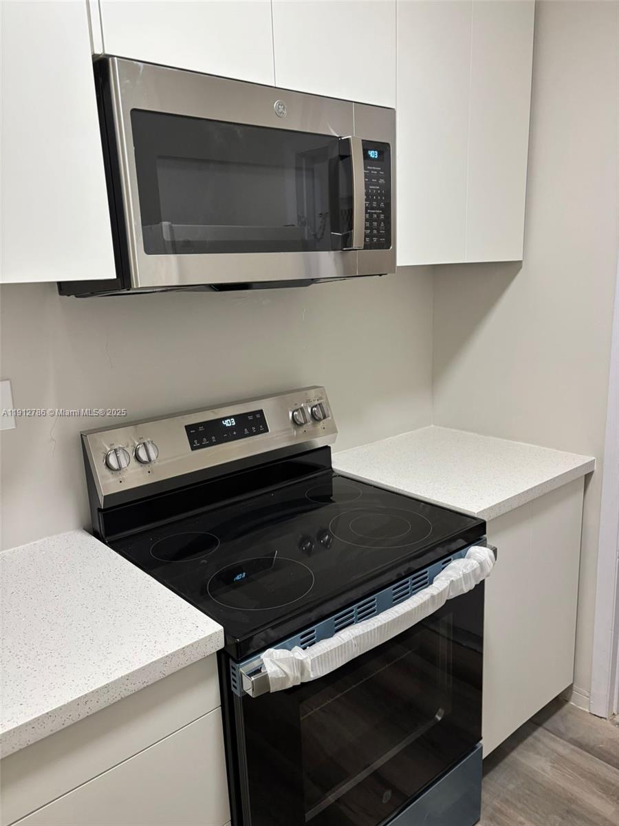 1420 Atlantic Shores Boulevard, Unit 340 Hallandale Beach, FL 33009 - Photo 7 of 33 a close view of a stove a microwave and cabinets