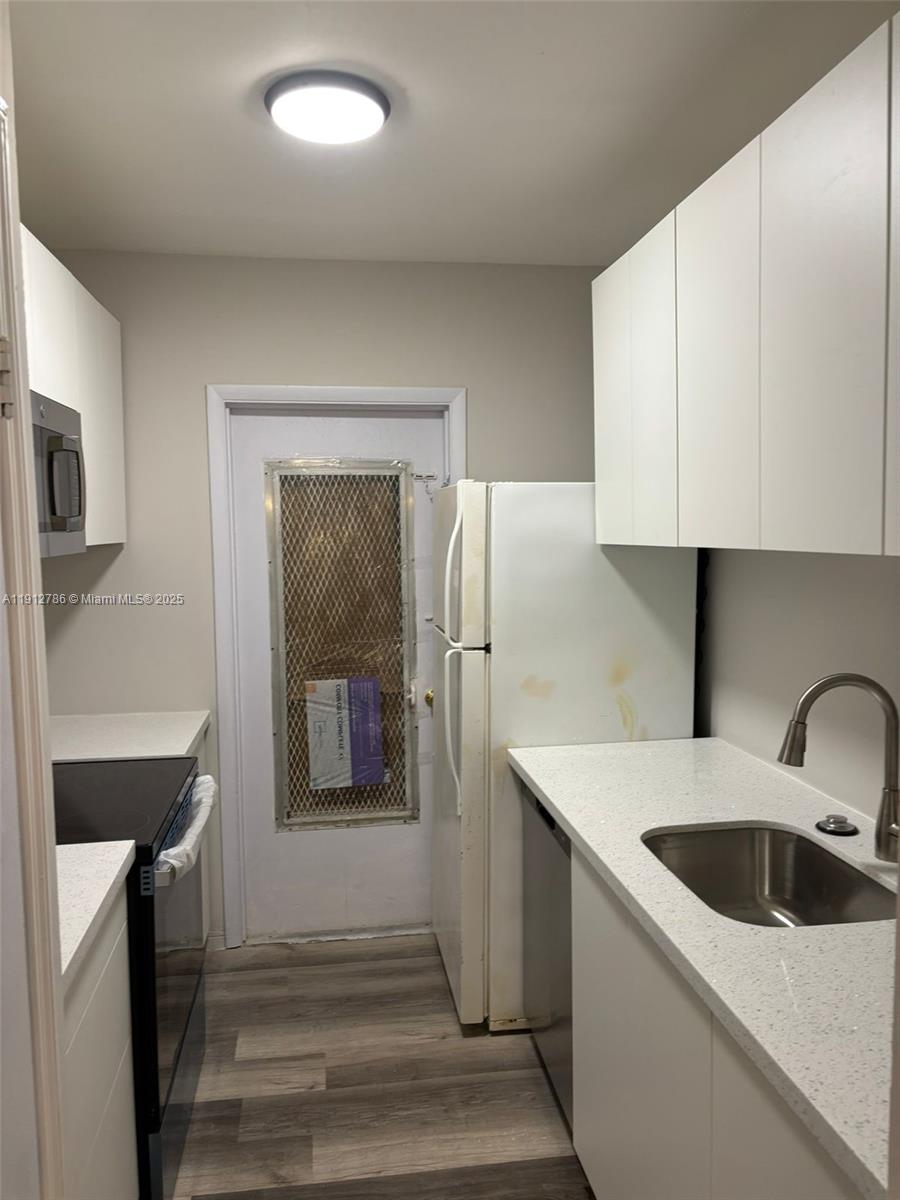 1420 Atlantic Shores Boulevard, Unit 340 Hallandale Beach, FL 33009 - Photo 8 of 33 a kitchen with a sink and a refrigerator