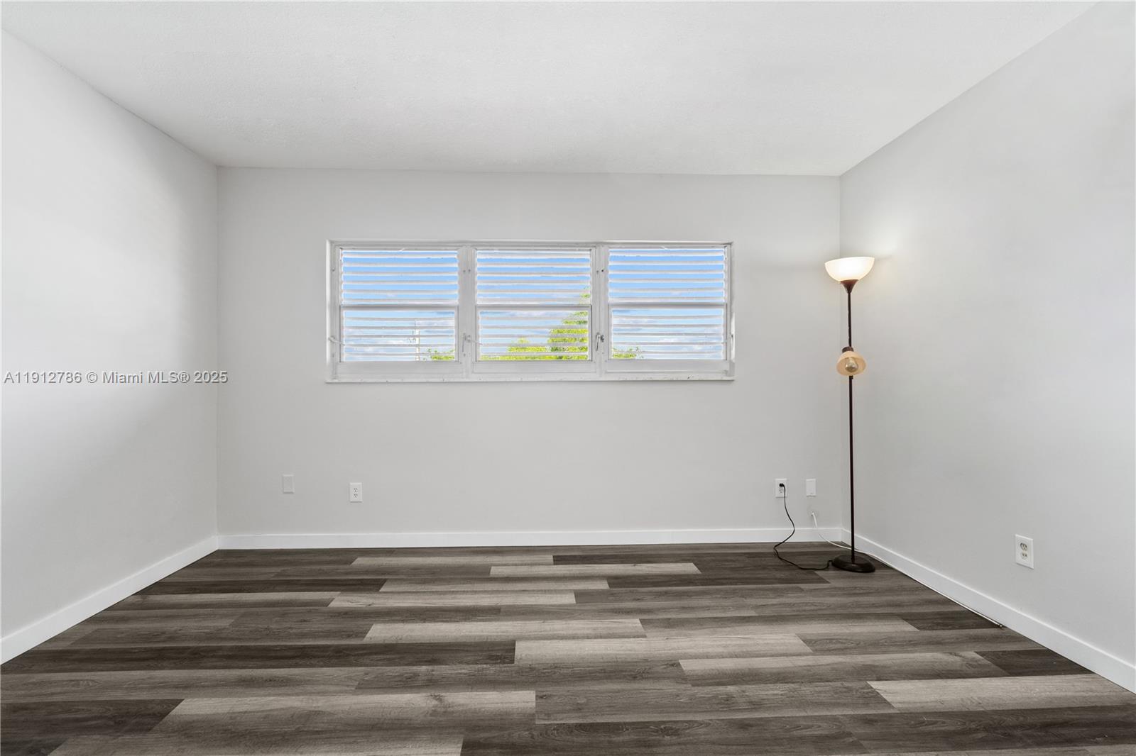 1420 Atlantic Shores Boulevard, Unit 340 Hallandale Beach, FL 33009 - Photo 10 of 33 a view of empty room with wooden floor and fan