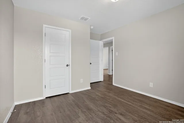 a view of an empty room with wooden floor