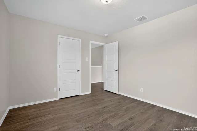 a view of an empty room with wooden floor
