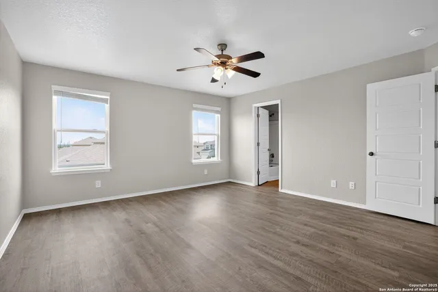 a view of a room with wooden floor and a ceiling fan