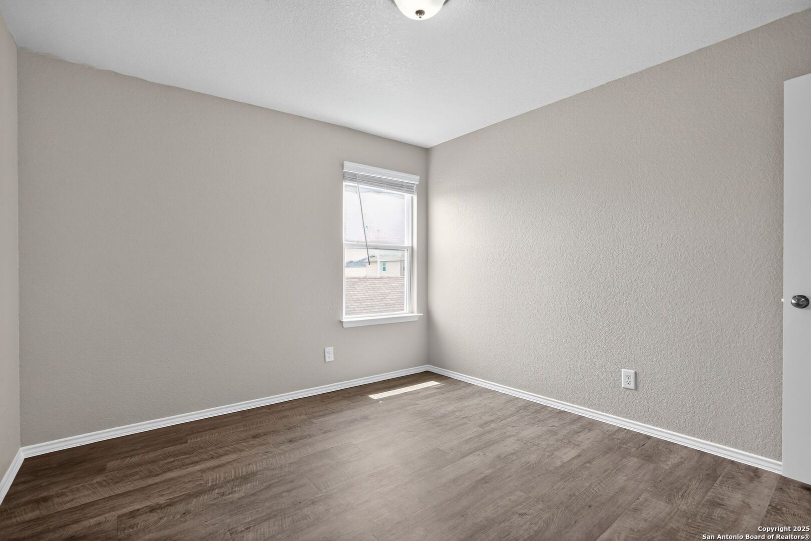 13008 Lineberry Lane St. Hedwig, TX 78152 - Photo 27 of 32 an empty room with wooden floor and windows