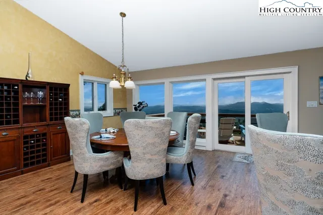 a dining room with furniture a chandelier and wooden floor