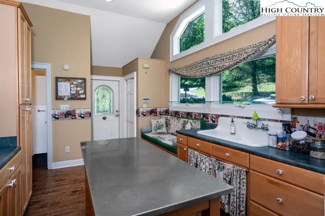 a kitchen with stainless steel appliances granite countertop a lot of counter space and a window