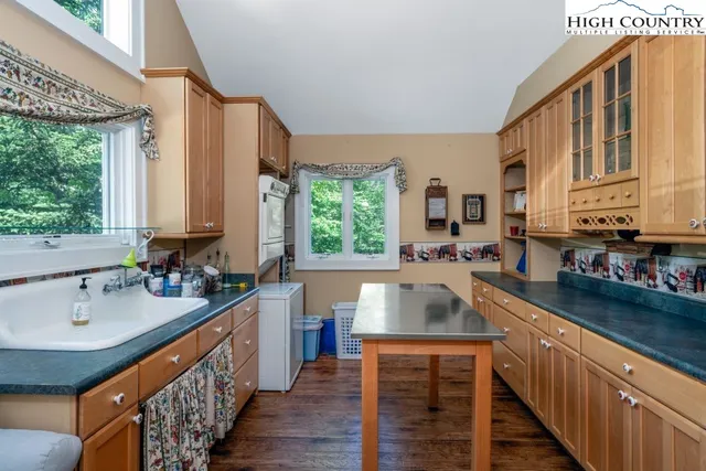 a kitchen with stainless steel appliances a sink window and cabinets