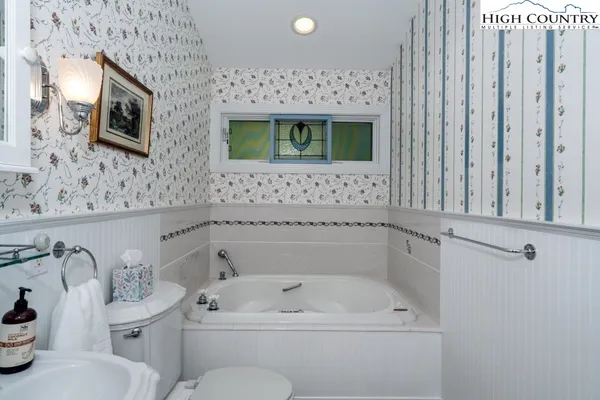 a bathroom with a sink a toilet and mirror