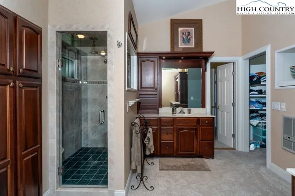 a bathroom with a mirror a sink and a glass door shower