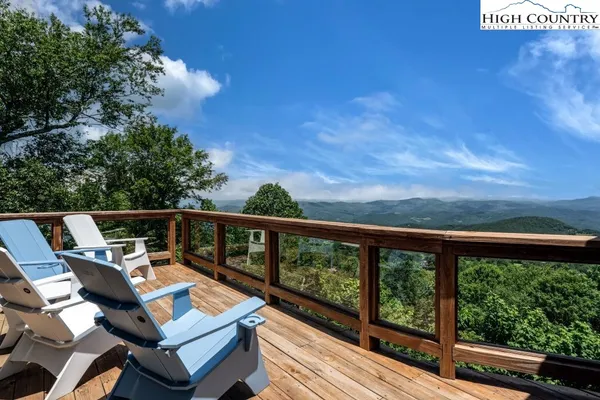 a view of roof deck with wooden floor and fence