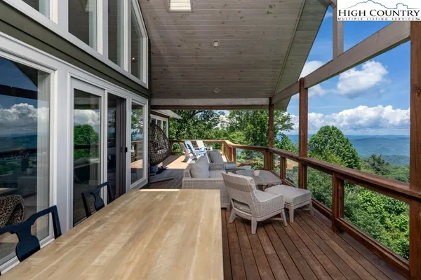 a view of a balcony with chairs and wooden floor