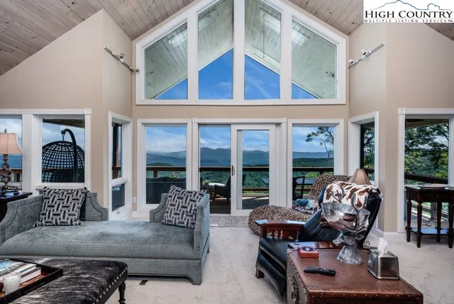 a living room with furniture fireplace and large windows