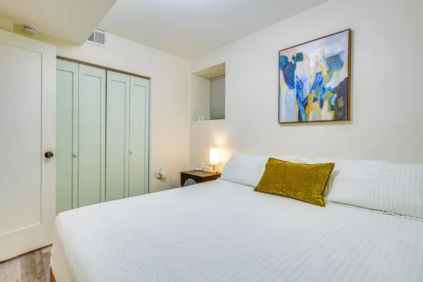 a bedroom with a bed and a painting on the wall