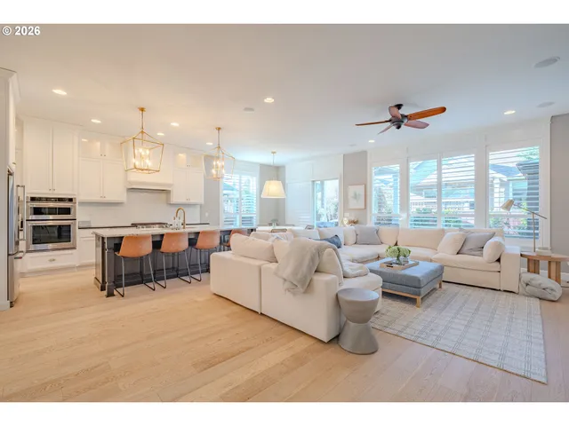 a living room with furniture kitchen view and a large window