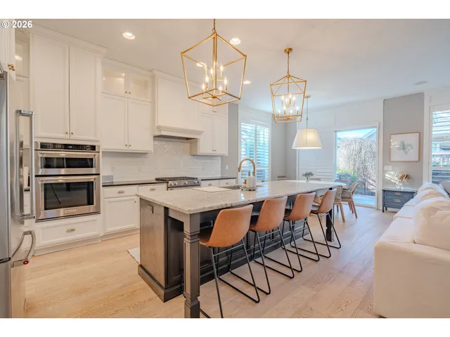 a kitchen with stainless steel appliances a dining table and chairs