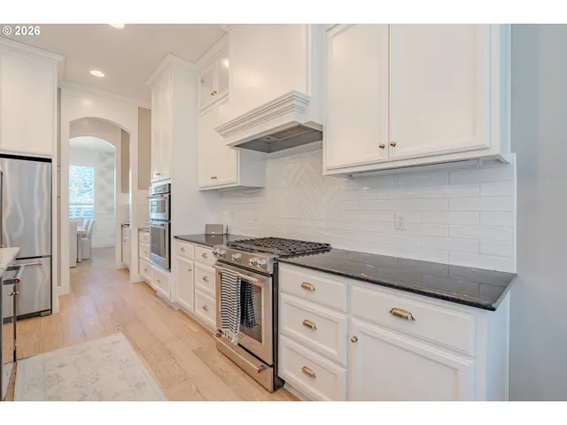 a kitchen with granite countertop white cabinets and appliances