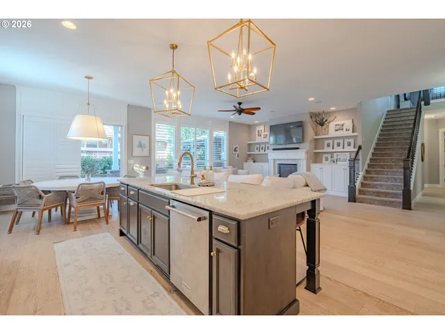 a kitchen with stainless steel appliances granite countertop a kitchen island a stove a table and chairs