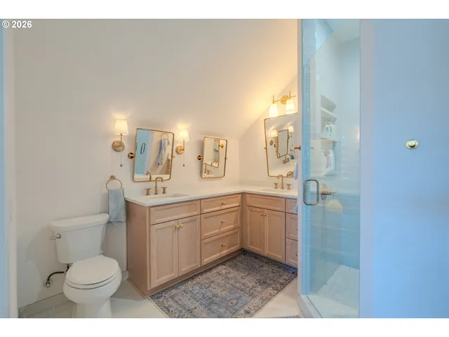 a bathroom with a toilet a sink a mirror and a shower