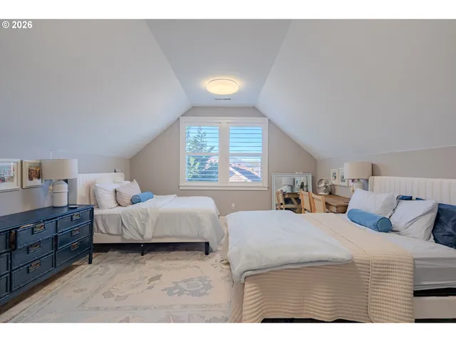 a bedroom with two beds and a lamp