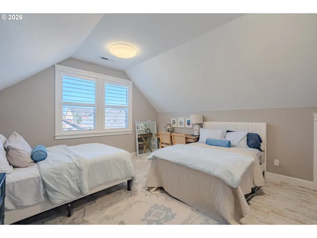 a bedroom with two beds and a large window