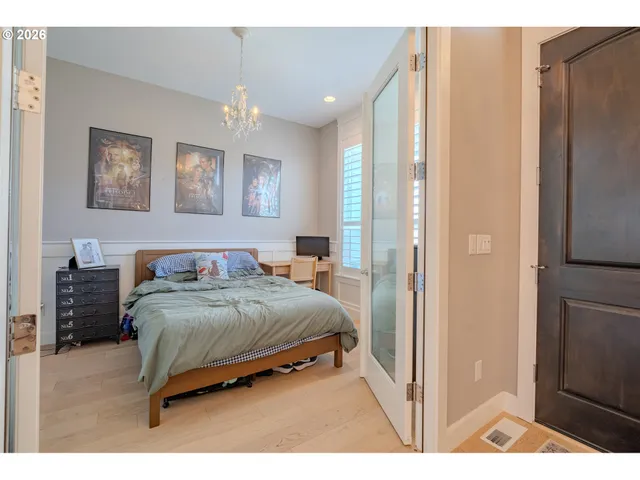 a bedroom with a large bed and a chandelier
