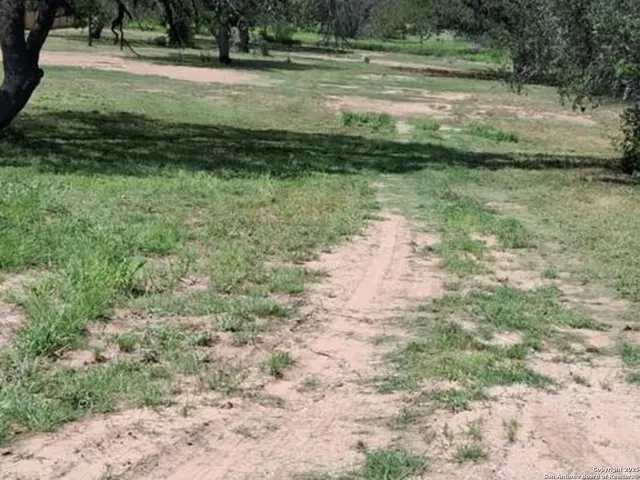 a view of a water pond with green yard