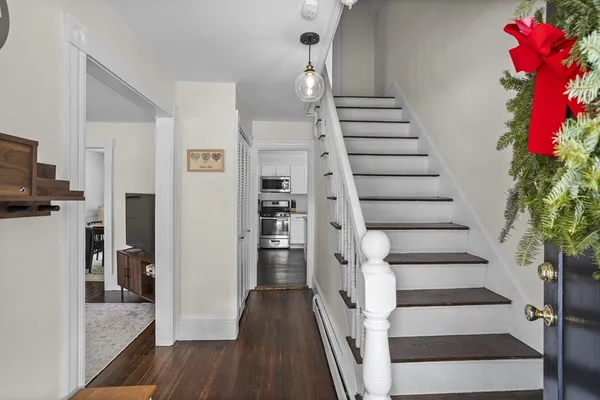 a view of entryway and hall with wooden floor