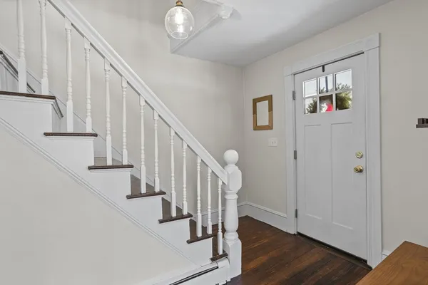 a view of staircase with wooden floor and white walls