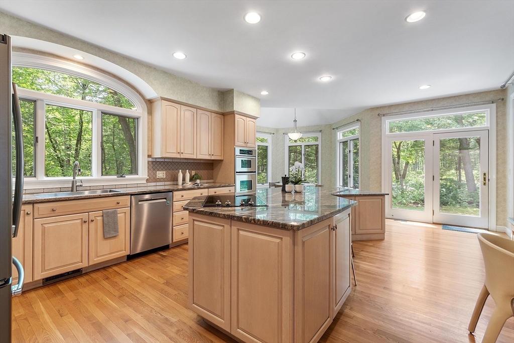 151 Pope Road Acton, MA 01720 - Photo 12 of 34 a kitchen with granite countertop center island wooden floor and a sink