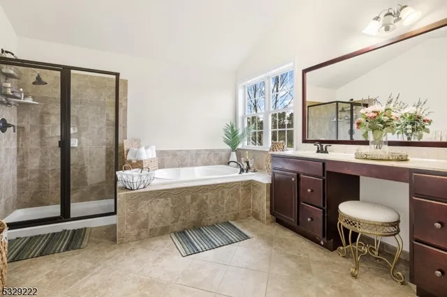 a spacious bathroom with a granite countertop sink mirror and a bathtub