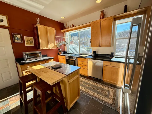 a kitchen with stainless steel appliances granite countertop a sink and a refrigerator