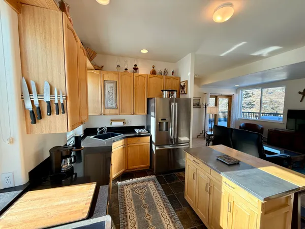 a kitchen with stainless steel appliances granite countertop a refrigerator a stove and a sink with wooden floor