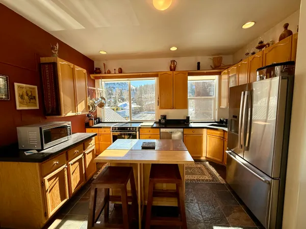 a kitchen with stainless steel appliances granite countertop a refrigerator a sink a stove and island