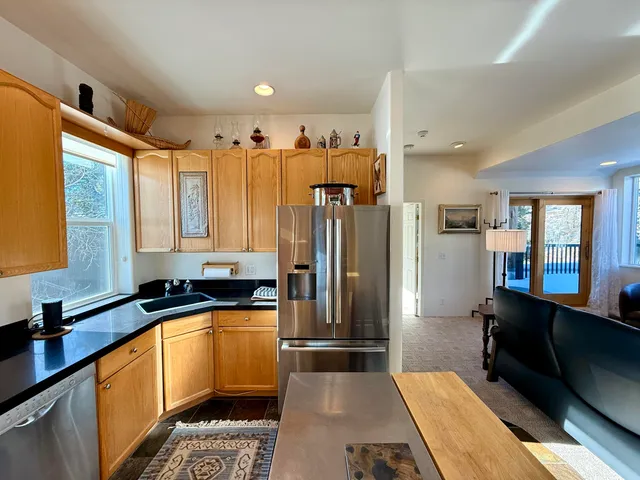 a kitchen with granite countertop a sink a counter top space a refrigerator and cabinets