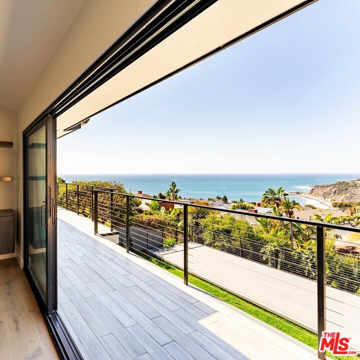 243 Notteargenta Road Pacific Palisades, CA 90272 - Photo 2 of 46 a view of a balcony with wooden floor with a city view