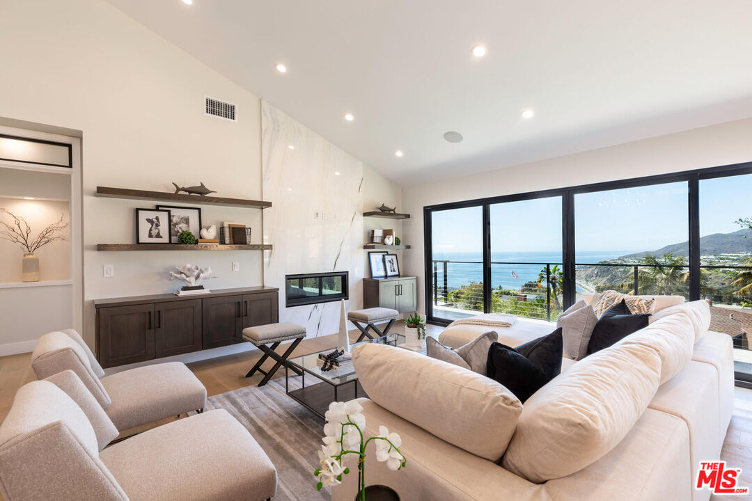 243 Notteargenta Road Pacific Palisades, CA 90272 - Photo 11 of 46 a living room with furniture and a large window