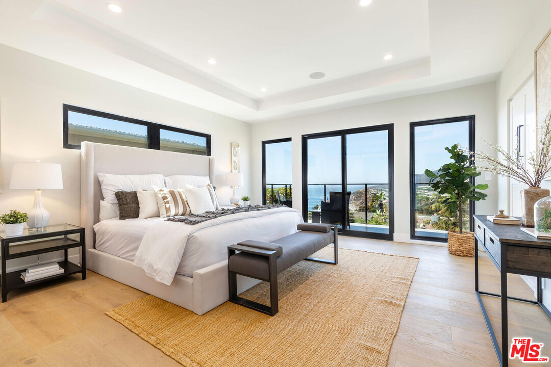 243 Notteargenta Road Pacific Palisades, CA 90272 - Photo 18 of 46 a spacious bedroom with a large bed and a large window