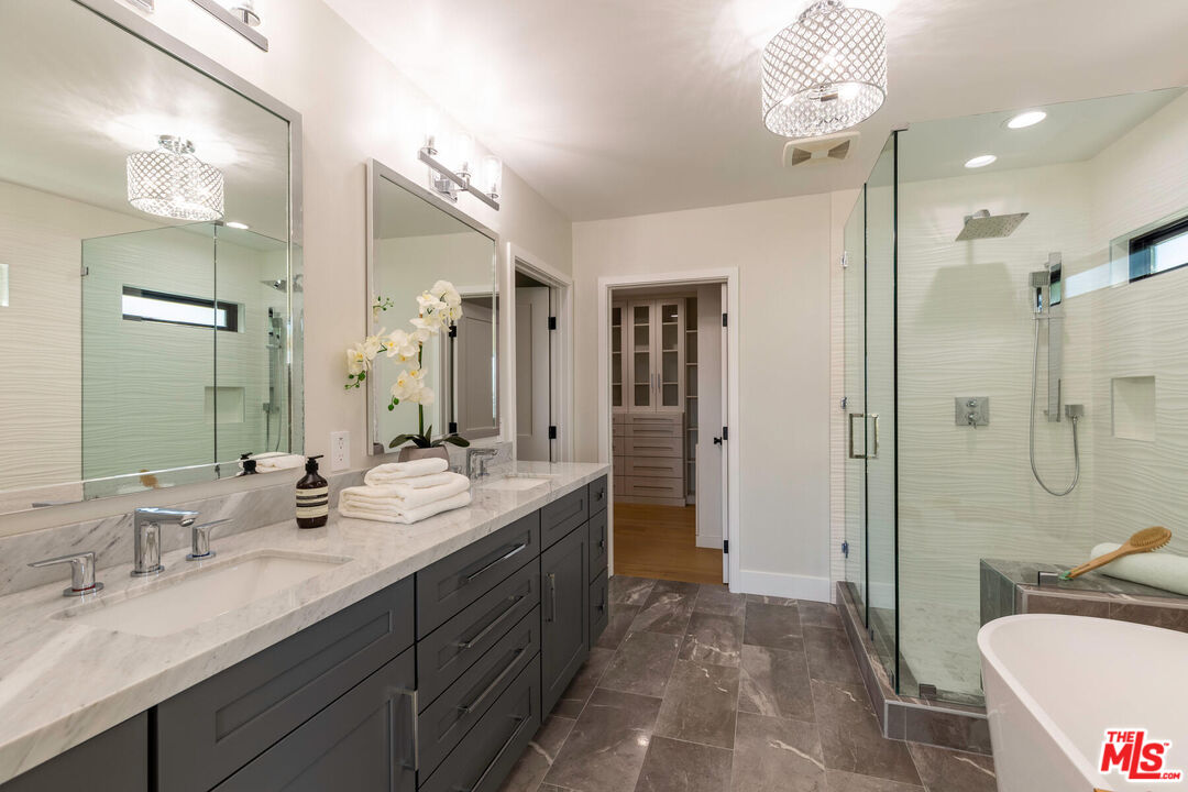 243 Notteargenta Road Pacific Palisades, CA 90272 - Photo 20 of 46 a bathroom with a granite countertop sink mirror and a shower