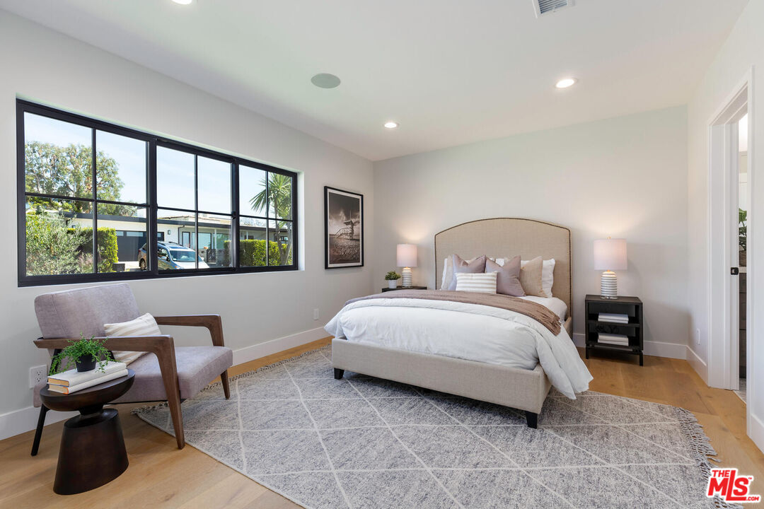 243 Notteargenta Road Pacific Palisades, CA 90272 - Photo 23 of 46 a bedroom with a bed and a large window