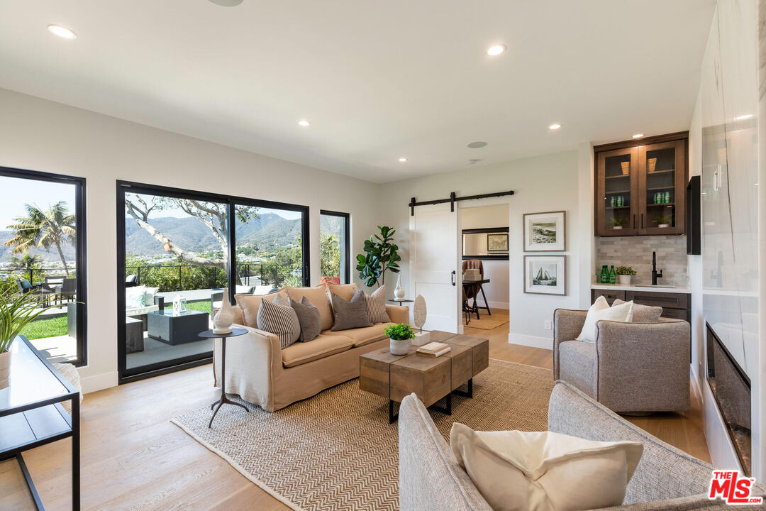 243 Notteargenta Road Pacific Palisades, CA 90272 - Photo 25 of 46 a living room with furniture and a large window