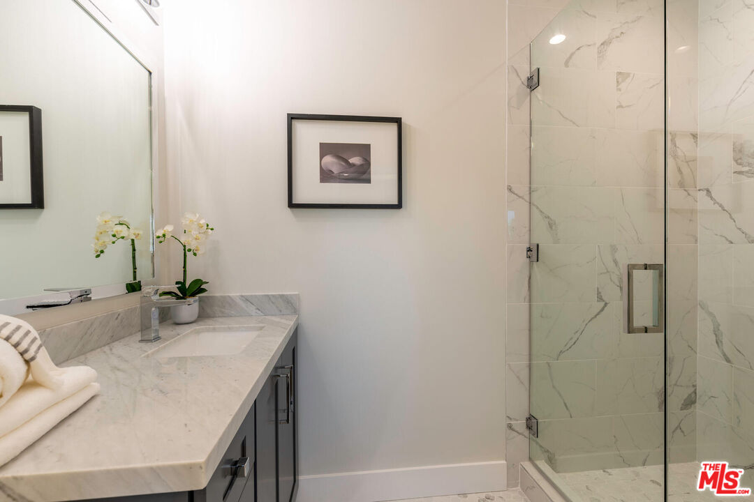243 Notteargenta Road Pacific Palisades, CA 90272 - Photo 33 of 46 a bathroom with a granite countertop sink a toilet and shower