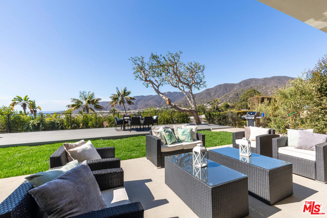 243 Notteargenta Road Pacific Palisades, CA 90272 - Photo 36 of 46 a view of a patio with couches chairs and a yard