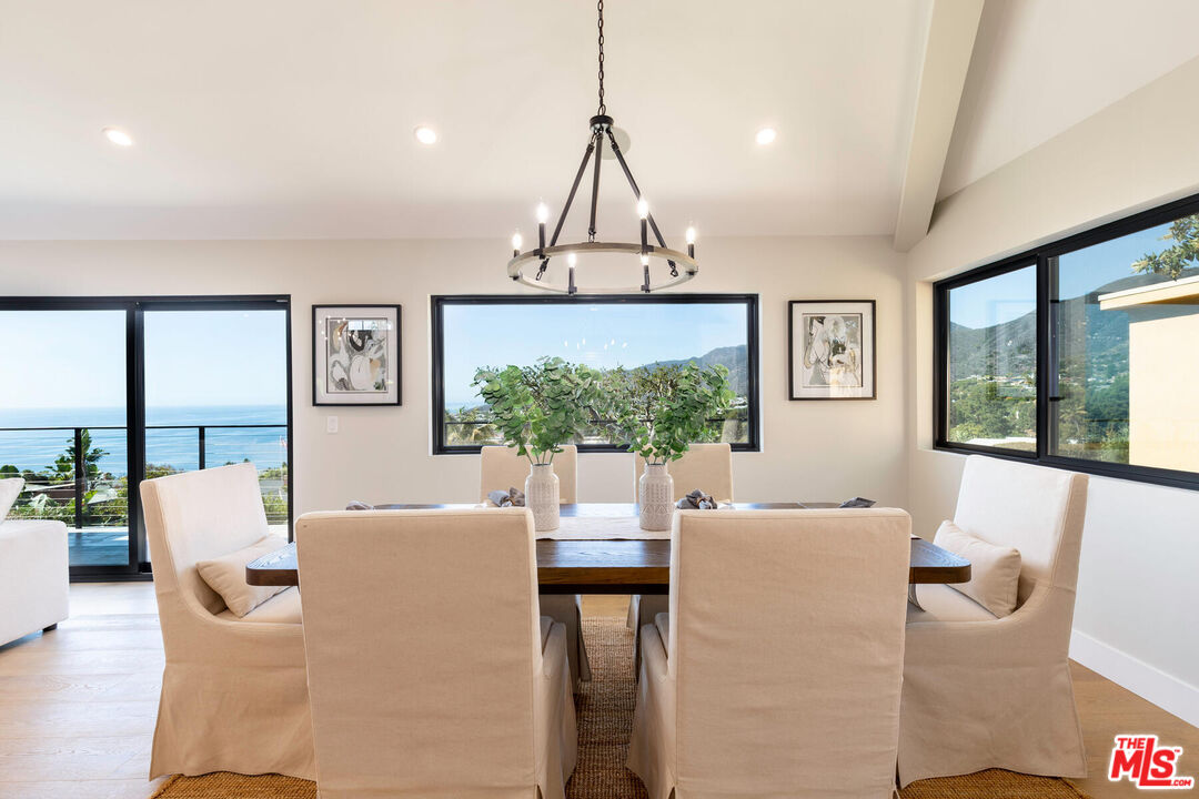 243 Notteargenta Road Pacific Palisades, CA 90272 - Photo 9 of 46 a living room with furniture a window and a chandelier