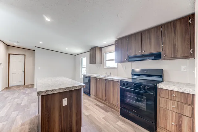 a kitchen with granite countertop cabinets stainless steel appliances and a counter space
