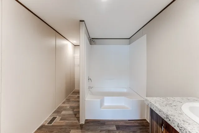 a bathroom with a granite countertop shower and a sink