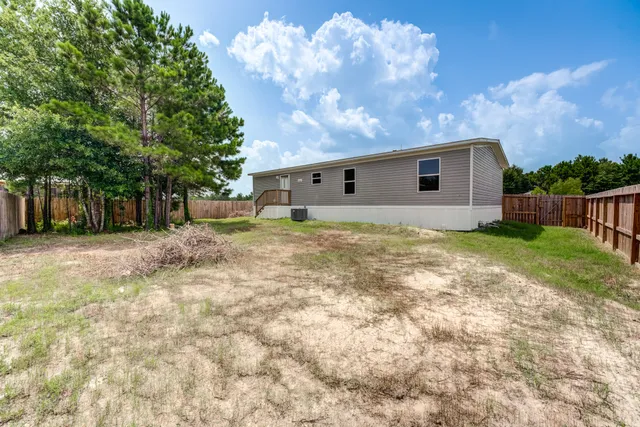 a backyard of a house with table and chairs