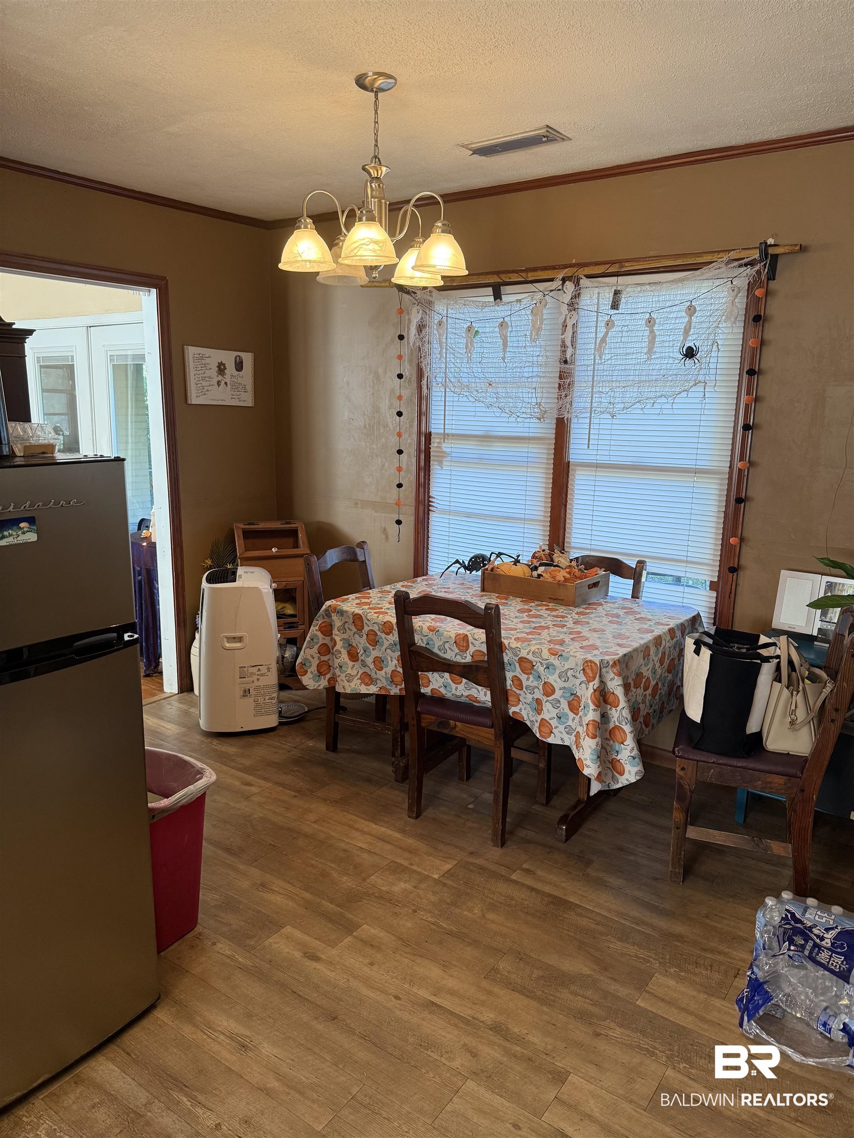 22173 1st Street Silverhill, AL 36576 - Photo 5 of 16 Dining space with a textured ceiling, light wood-style floors, ornamental molding, and a chandelier