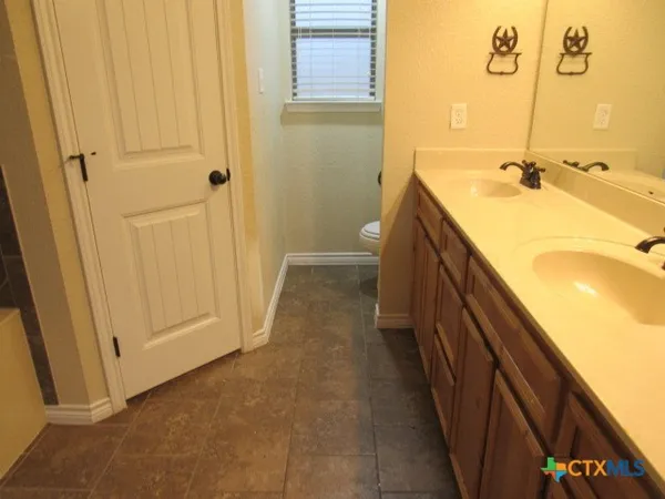 a bathroom with a double vanity sink and a mirror