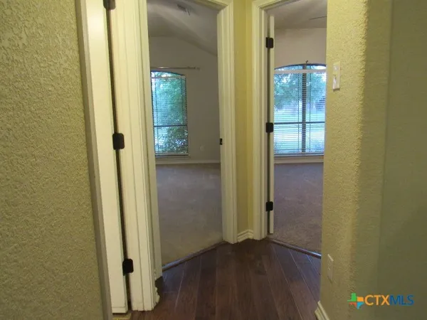an empty room with wooden floor and a bathroom