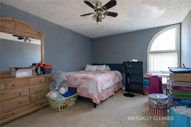 a spacious bedroom with a bed and a window