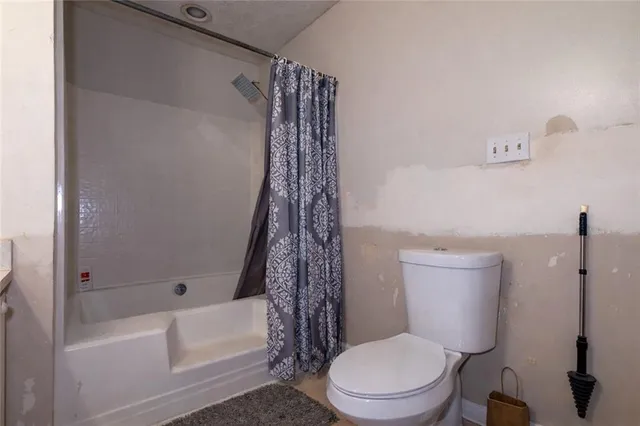 a white toilet sitting next to a bath tub